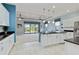 Bright kitchen featuring white cabinets, black countertops, and an island with pendant lighting at 10618 Corkwood Ct, Venice, FL 34293
