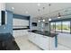 Spacious kitchen with a center island, white cabinets, and a seamless transition to the living area at 10618 Corkwood Ct, Venice, FL 34293