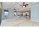 Spacious living room with a tray ceiling, ceiling fans, open floor plan, and adjoins the kitchen with island at 10618 Corkwood Ct, Venice, FL 34293