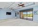 Carpeted living room with a ceiling fan, large sliding glass doors leading to outdoor space with lawn views at 10618 Corkwood Ct, Venice, FL 34293