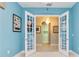 Office featuring double doors leading to a laundry room with blue walls, and a hanging chandelier at 10618 Corkwood Ct, Venice, FL 34293