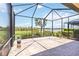 Screened-in lanai with brick flooring and a peaceful view of the lake at 10618 Corkwood Ct, Venice, FL 34293