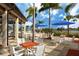 Outdoor patio area with tables, chairs, and umbrellas overlooking the pool and lake, ideal for dining at 10618 Corkwood Ct, Venice, FL 34293