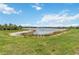 Scenic pond view with lush green grass and bright blue skies, offering a serene and peaceful setting at 10618 Corkwood Ct, Venice, FL 34293
