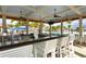 Charming poolside bar area featuring granite countertops, ceiling fans, and comfortable seating at 10618 Corkwood Ct, Venice, FL 34293