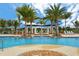 Stunning community pool featuring fountains, lounge chairs, and tropical landscaping, offering a luxurious experience at 10618 Corkwood Ct, Venice, FL 34293