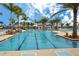 Stunning community pool surrounded by palm trees and lounge chairs, perfect for relaxation at 10618 Corkwood Ct, Venice, FL 34293