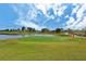 Picturesque golf course showcasing lush green fairways, a tranquil pond, and clear blue skies at 10618 Corkwood Ct, Venice, FL 34293