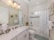 Bright bathroom featuring a shower-over-tub, large vanity, and beachy artwork, providing both style and functionality at 10973 Trevino St, Englewood, FL 34223