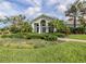 Attractive building exterior with lush landscaping and palm trees under a cloudy blue sky at 10973 Trevino St, Englewood, FL 34223