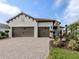 This home features a three-car garage and a brick paved drive at 10973 Trevino St, Englewood, FL 34223