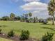 A row of golf carts is ready for a round on the lush green course in a sunny, picturesque setting at 10973 Trevino St, Englewood, FL 34223