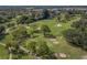 Picturesque aerial view of a golf course with lush fairways, sand traps, and mature trees creating a verdant landscape at 10973 Trevino St, Englewood, FL 34223