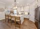 Well-lit kitchen with white cabinets, stainless steel appliances, and a large island with bar stools, perfect for cooking at 10973 Trevino St, Englewood, FL 34223