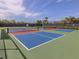 Vibrant, multi-colored pickleball courts offer a fun recreational activity on a sunny day with wispy clouds at 10973 Trevino St, Englewood, FL 34223