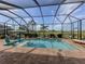 Serene screened-in pool area with comfortable seating, picturesque landscaping, and clear skies, offering an outdoor paradise at 10973 Trevino St, Englewood, FL 34223