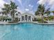 Beautiful community pool with clear blue water, lounge chairs, and a clubhouse in the background at 10973 Trevino St, Englewood, FL 34223