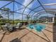 Captivating screened-in pool with lush landscaping, ample seating, and tranquil views, perfect for outdoor enjoyment at 10973 Trevino St, Englewood, FL 34223