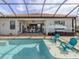 Inviting pool area with comfortable seating, umbrella shade, and views of the home, creating a relaxing outdoor retreat at 10973 Trevino St, Englewood, FL 34223