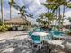 Outdoor dining area with a tiki hut, grill, and seating perfect for entertaining by the pool at 10973 Trevino St, Englewood, FL 34223