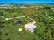 Picturesque aerial view of estate featuring lush landscaping, private pond, luxurious pool, and meticulously maintained grounds at 1104 Twin Laurel Blvd, Nokomis, FL 34275
