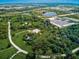 Aerial image of a beautiful estate on a large lot with a private pond, luxurious pool, commercial area, and lush landscaping at 1104 Twin Laurel Blvd, Nokomis, FL 34275