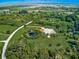 Picturesque aerial view of estate featuring lush landscaping, private pond, luxurious pool, and meticulously maintained grounds at 1104 Twin Laurel Blvd, Nokomis, FL 34275