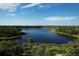 Beautiful aerial view of lake surrounded by lush green trees and upscale homes at 12478 Sagewood Dr, Venice, FL 34293