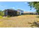 Large backyard with grass and landscaping, and a screened-in patio with room for grilling and furniture at 12478 Sagewood Dr, Venice, FL 34293