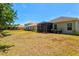 The backyard features grass and landscaping, plus a screened patio area for entertaining at 12478 Sagewood Dr, Venice, FL 34293