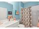 Bathroom featuring a sink and vanity, toilet, and shower/bath with patterned shower curtain at 12478 Sagewood Dr, Venice, FL 34293
