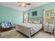Cozy bedroom with natural light, a ceiling fan, and neutral decor for a relaxing atmosphere at 12478 Sagewood Dr, Venice, FL 34293