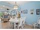 Bright dining area with white wicker furniture and decorative light fixture, open to the living space at 12478 Sagewood Dr, Venice, FL 34293