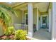 Inviting front porch with neutral decor, a glass front door, and serene landscaping for a relaxing welcome at 12478 Sagewood Dr, Venice, FL 34293