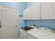 Laundry room with side by side washer and dryer and white storage cabinets at 12478 Sagewood Dr, Venice, FL 34293