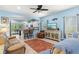 Bright living room with a ceiling fan, tile floors, and an open layout leading to the kitchen and dining area at 12478 Sagewood Dr, Venice, FL 34293