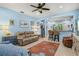 Comfortable living room with blue walls, a ceiling fan, and an open floor plan connecting to the kitchen at 12478 Sagewood Dr, Venice, FL 34293