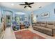 Spacious living room featuring tile flooring, ceiling fan, and an open view into the dining room for easy entertaining at 12478 Sagewood Dr, Venice, FL 34293