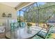 Screened in patio with outdoor dining table, chairs, and grill overlooking the backyard at 12478 Sagewood Dr, Venice, FL 34293