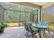 Screened in patio with outdoor dining table, chairs, and grill overlooking the backyard at 12478 Sagewood Dr, Venice, FL 34293