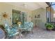Screened patio with ceiling fan and sliding glass door to the home’s interior and outdoor furniture at 12478 Sagewood Dr, Venice, FL 34293