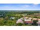 A captivating aerial view of the community nestled among lush greenery and mature trees under a clear blue sky at 129 Preserve Pl # D, Nokomis, FL 34275