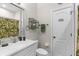 Bathroom showcasing a sink, toilet, tropical-themed shower curtain and towel rack, creating a refreshing and functional space at 129 Preserve Pl # D, Nokomis, FL 34275