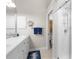 Bathroom features a dual sink vanity with mirror, light fixtures, white cabinets, blue accents, shower, and wall storage at 129 Preserve Pl # D, Nokomis, FL 34275