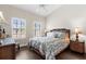 Bedroom with plantation shutters and hardwood floors showcasing tropical decor with rattan furnishings at 129 Preserve Pl # D, Nokomis, FL 34275