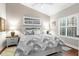 Bedroom with beach-themed artwork, neutral tones, and shuttered windows creating a peaceful and serene retreat at 129 Preserve Pl # D, Nokomis, FL 34275