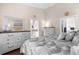 Well-lit bedroom with artwork, hardwood floors and neutral decor for a soothing and restful ambiance at 129 Preserve Pl # D, Nokomis, FL 34275