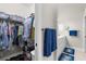 The image features the walk-in closet with clothes hanging on racks plus a bathroom area with a vanity and blue towels at 129 Preserve Pl # D, Nokomis, FL 34275