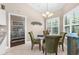 Dining area featuring a glass table with seating for four near a window with shutters, open to bedroom at 129 Preserve Pl # D, Nokomis, FL 34275