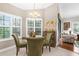 Features a glass table with seating for four, shuttered windows, and an open flow to the living area at 129 Preserve Pl # D, Nokomis, FL 34275